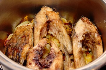 Fried cut on carp pieces on a metal pan
