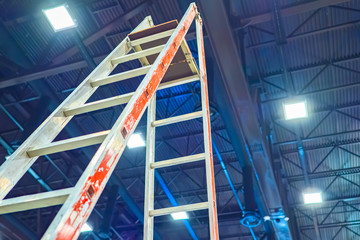 Ladder close-up. The stepladder is in a large room. Repair work. Preparation for the exhibition. Maintenance of the building. Device for working at height.