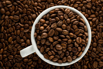 coffee grains in a white cup on a background of coffee grains