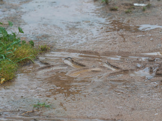 Drops falling on the ground with a tractor wheel footprint