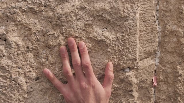 Wailing Wall or Western Wall in Jerusalem. Close-up of a hand tuching stones Western Wall or Kotel. A men praying at the Wailing Wall in the old city of Jerusalem.
