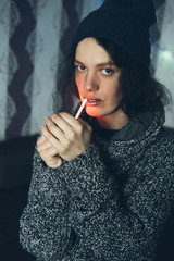 Obraz premium Young Female setting fire to cigarette with lighter