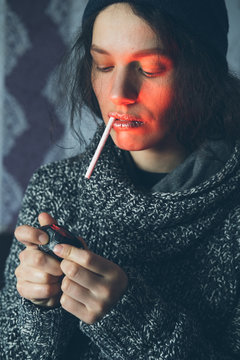 Young Female setting fire to cigarette with  lighter