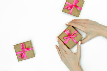 flat-lay of Gift present boxes with female hands and pink ribbon on white background. Copy space