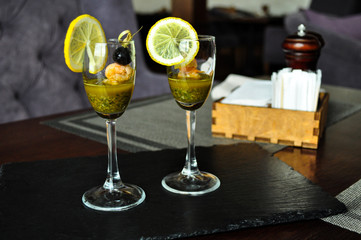 Canapé shrimp on a skewer with pesto sauce in a glass