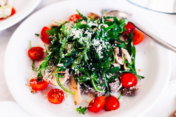 top view of salad covered with arugula leaves and decorated with