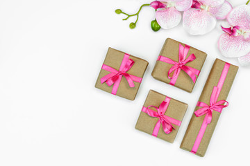 banner of Gift present box with pink ribbon with orchid flowers on white background flat lay. spring concept. Copy space