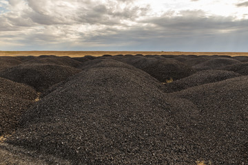 large piles of old asphalt in the steppe after road repair, Kazakhstan