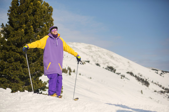 skier wearing snowboarding hoody sports gear posing with his ski looking away enjoying sunny day at the mountains. Activities leisure lifestyle, winter sports concept