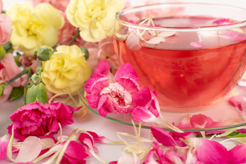 Pink Flower Tea with Carnation Petals. Hot Rose Drink in Glass Cup