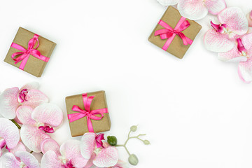 flat-lay of Gift present boxes with pink ribbon with orchid flowers on white background. spring concept. Copy space