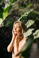 Woman in swimsuit on tropical plants background