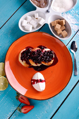 Cottage cheese pancakes with currant on a plate