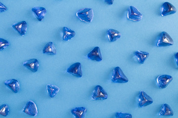 Decorative blue glass stones on the blue  background. Top view. Flat lay.