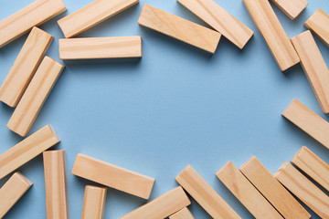 Wooden blocks on a blue background for copy space in center.