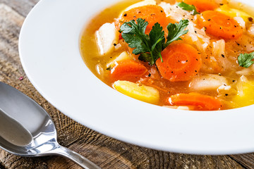 Bowl of hot cabbage soup on wooden table