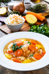 Bowl of hot cabbage soup on wooden table