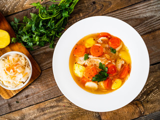 Bowl of hot cabbage soup on wooden table