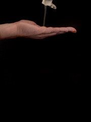 Hand with sanitizer gel on black background with copy space