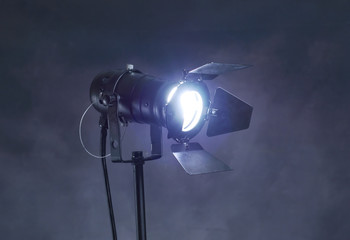 A studio spotlight facing the camera on a dark grunge background