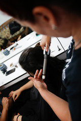 stylists working with a woman in her hands and hair