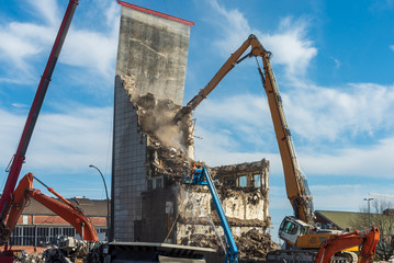 Bagger bei Abrissarbeiten eines Hochhauses
