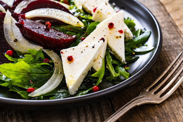  Beetroot salad with feta cheese on wooden background
