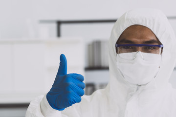 Lab Technician in Personal protective equipment  PPE suit Good hand gesture