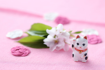 Obraz na płótnie Canvas 商売繁盛の招き猫と桜の花（オオシマザクラ）