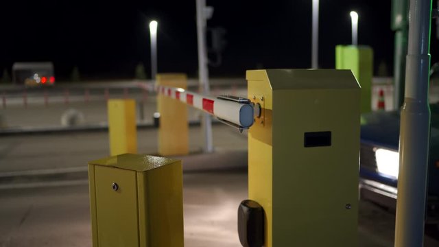 Car auto parking at the airport terminal security system boom barrier gate at night