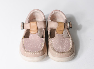 cute little vintage retro pink baby dolly shoes, isolated on a white studio background.  Tiny baby sneakers for a baby shower. Babies feet grow fast.