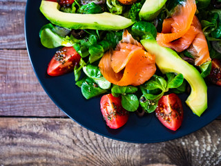Salmon salad - smoked salmon and vegetables on wooden background
