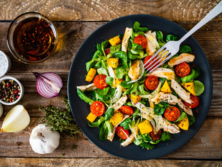 Caesar salad - fried chicken breast and vegetables on wooden table