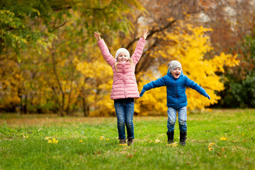 Naklejka na ściany i meble Adorable little girl and boy outdoors at beautiful autumn day