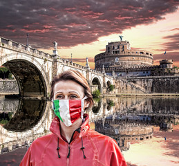 Woman wearing protection face mask with Italian flag against coronavirus in front of the Angel...