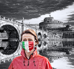 Woman wearing protection face mask with Italian flag against coronavirus in front of the Angel...