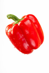 Ripe red bell pepper in droplets of water, isolate on white.