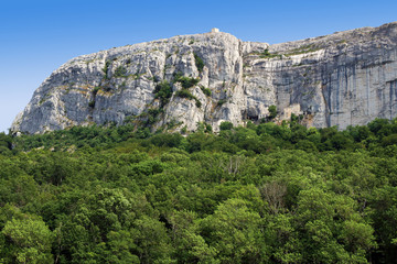 Fototapeta na wymiar Sanctuaire de la Sainte-Baume installé dans une grotte au pied de la falaise, au dessus de la forêt domaniale.