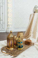 Oriental bronze lanterns on a gold carved tray interior details. Metal lanterns candle holders in...