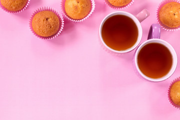 Obraz na płótnie Canvas cups of tea and fresh cupcakes on a pink background top view. background with tea cups and muffins.