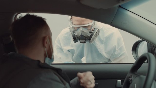 Patient is being tested in his vehicle on a drive-through coronavirus COVID-19 testing location. Pandemic, infection