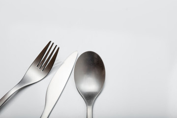 Cutlery on white table. Minimal designed fork, knife and spoon on clear, white background