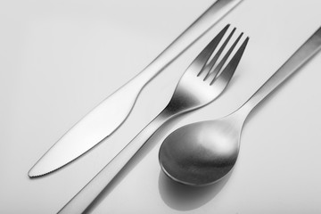 Cutlery on white table. Minimal designed fork, knife and spoon on clear, white background
