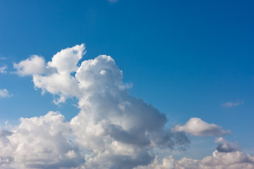 Cumulus fluffy clouds in the blue sky, in March, in windy weather. Sky pattern.	
