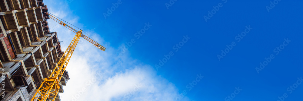 Wall mural construction site and yellow crane on the background blue sky, panoramic mock-up - Wall murals