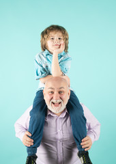 Senior man giving his grandson a piggyback. Male Family Concept. Positive Boy, Father And Son.