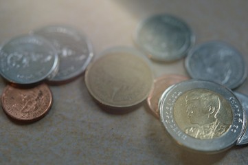 The close-up group of a Thai coins placed on the floor selective focus and shallow depth of field.