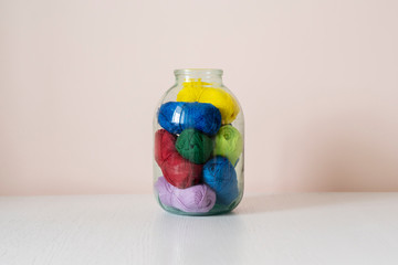 some yarn rolls of different color put inside the glass bank at home, creative storage sollution