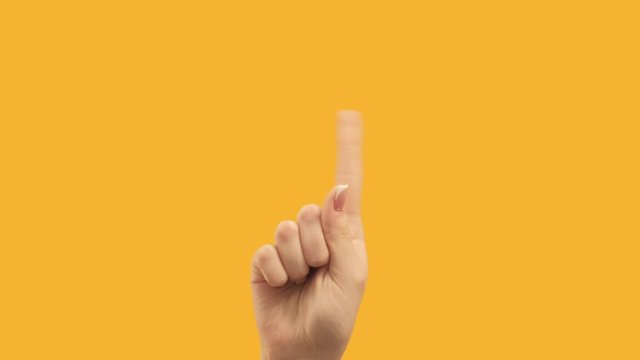 Finger signal. Disapproving gesture. Female hand showing no isolated on copyspace orange background.
