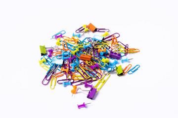 imagen cenital Puñado de Chinchetas, clips y pinzas de colores para organizar tus papeles sobre fondo blanco